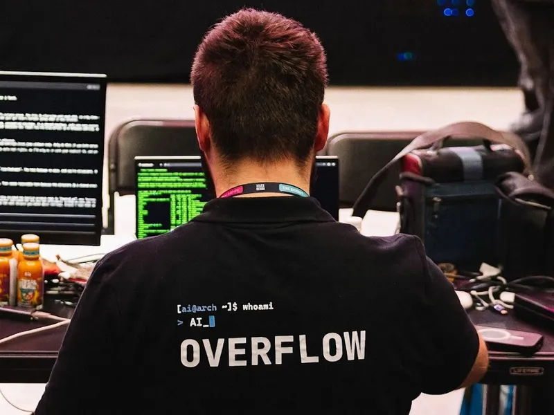 Alan Balcerowiak przy laptopie podczas HackYeah 2026, widok od tyłu, koszulka z napisem OVERFLOW